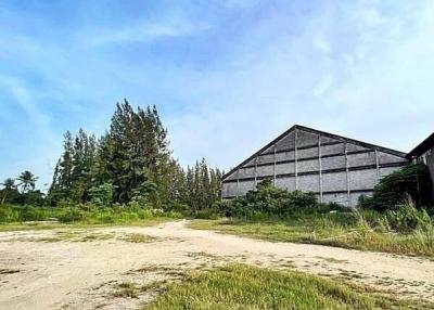 Spacious open land near a large building under a clear blue sky