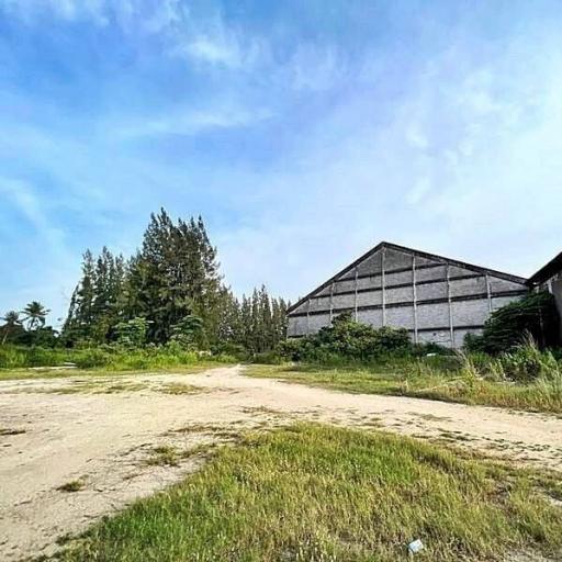 Spacious open land near a large building under a clear blue sky