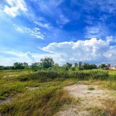 Expansive open lot under blue sky with clouds