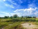 Expansive open lot under blue sky with clouds