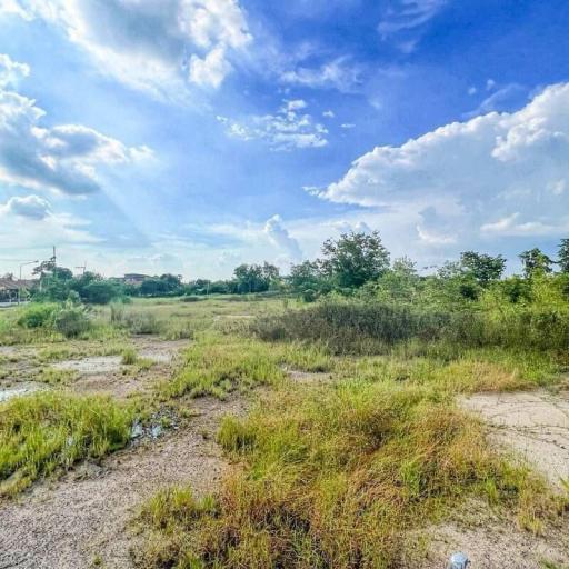 Spacious open land under a clear blue sky with clouds