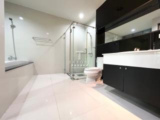 Modern bathroom with a glass shower enclosure, bathtub, and extended vanity