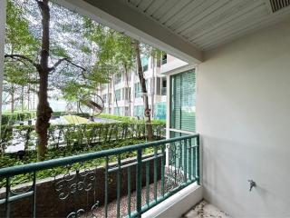 Spacious balcony with a view of green outdoor area and neighboring buildings