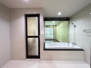 Modern bathroom with a bathtub and glass shower partition