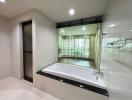 Modern bathroom with large bathtub and transparent shower partition