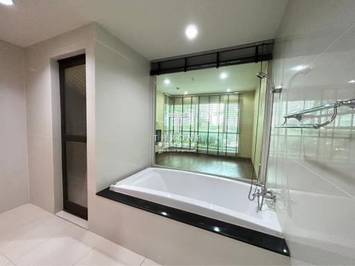 Modern bathroom with large bathtub and transparent shower partition