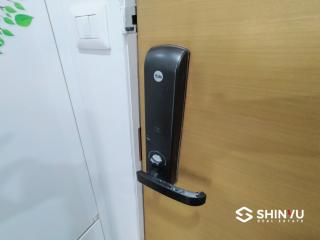 Modern digital lock on a wooden front door of an apartment