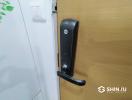 Modern digital lock on a wooden front door of an apartment