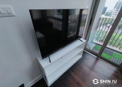 Modern living room with large flat-screen TV and balcony access