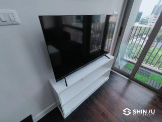 Modern living room with large flat-screen TV and balcony access