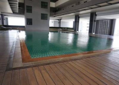 Indoor swimming pool with wooden decking and ambient lighting