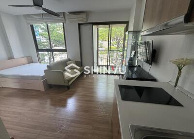 Studio apartment with bed, sofa, kitchenette and large windows