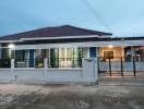 Modern single-story house with illuminated windows at dusk