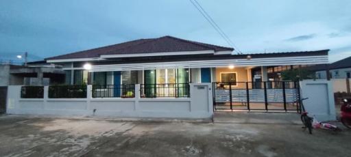 Modern single-story house with illuminated windows at dusk