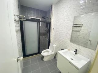 Modern bathroom with shower and white tiling