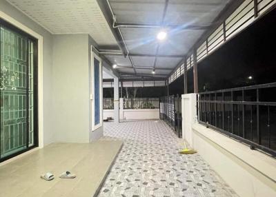 Spacious covered balcony with patterned flooring in an apartment building at night