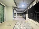 Spacious covered balcony with patterned flooring in an apartment building at night