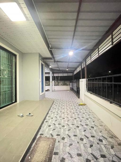 Spacious covered balcony with patterned flooring in an apartment building at night