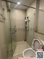 Modern bathroom with glass shower enclosure and white ceramic fixtures