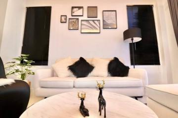 Cozy living room with a white sofa, decorative black pillows, and wall art
