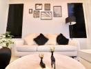 Cozy living room with a white sofa, decorative black pillows, and wall art