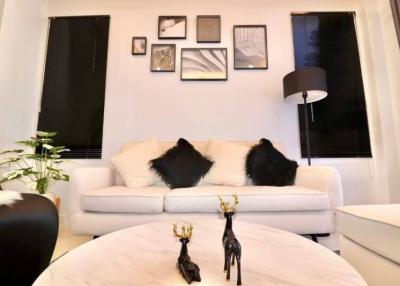 Cozy living room with a white sofa, decorative black pillows, and wall art