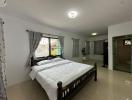 Spacious and well-lit bedroom with a king-sized bed and modern amenities