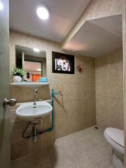 Well-maintained bathroom with tiled walls, mirror, and essential fixtures