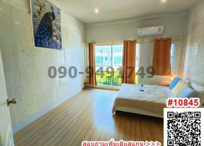 Spacious and bright bedroom with queen-sized bed, ample lighting, and wooden flooring