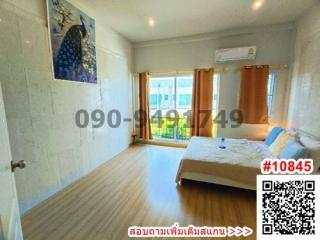 Spacious and bright bedroom with queen-sized bed, ample lighting, and wooden flooring