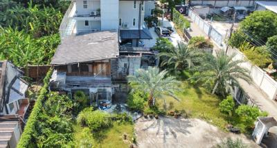 Aerial view of a residential property with a mix of modern and traditional buildings surrounded by lush greenery