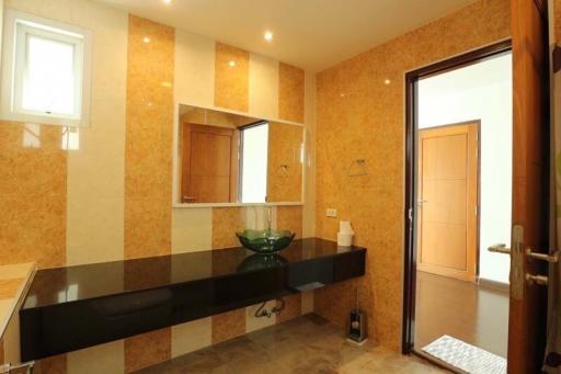 Contemporary bathroom with cork tiles and dark countertop