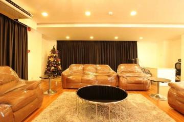 Spacious living room with protective plastic-covered sofas and a Christmas tree