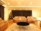 Spacious living room with protective plastic-covered sofas and a Christmas tree