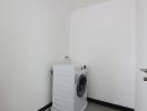 Compact laundry room with washing machine and white walls
