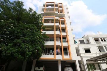 Modern multi-story residential building with balconies and parking space