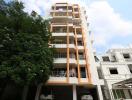 Modern multi-story residential building with balconies and parking space