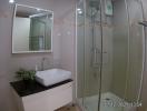 Modern bathroom interior with glass shower and white basin