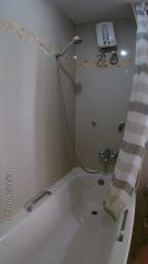 Compact tiled bathroom with bathtub and shower