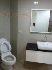 Modern bathroom with tiled walls and white porcelain fixtures