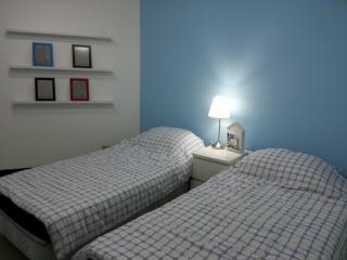 Cozy Bedroom with Two Single Beds and Blue Accent Wall