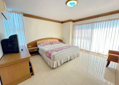 Spacious bedroom with large windows and tiled flooring