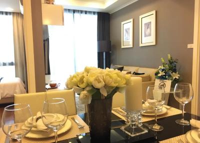 Elegantly decorated living room with dining area and a glimpse of the bedroom