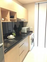 Compact modern kitchen with built-in appliances and washing machine