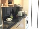 Compact modern kitchen with built-in appliances and washing machine