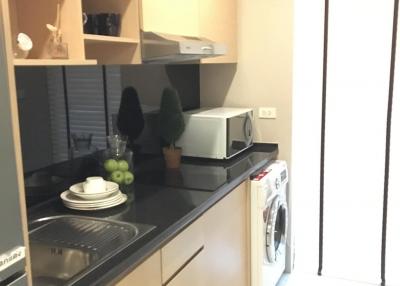 Compact modern kitchen with built-in appliances and washing machine