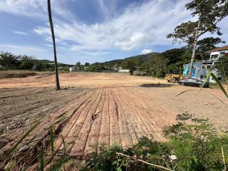 Vacant land ready for construction with blue sky and suburban backdrop