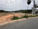 Empty residential lot under a cloudy sky