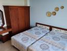 Bright and airy bedroom with double bed, wooden wardrobe, and balcony access