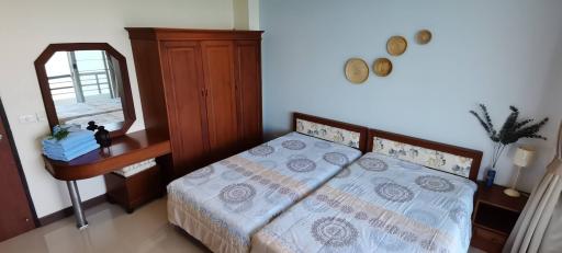 Bright and airy bedroom with double bed, wooden wardrobe, and balcony access